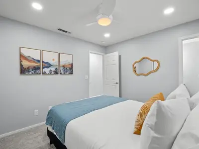 a white bedroom with a bed and a mirror at Serene Views with Hot Tub, BBQ, Fire Pit, Game Room in Oakhurst