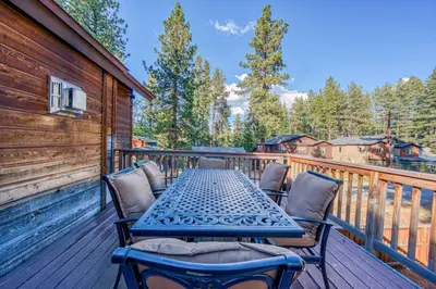 a wooden deck with a table and chairs on it at Tahoe Island Retreat Hot Tub & Game Room in South Lake Tahoe