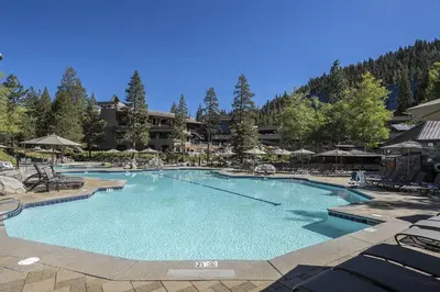 a large swimming pool with chairs and umbrellas at a resort at Community Perks! Everline Resort and Spa Retreat in Olympic Valley