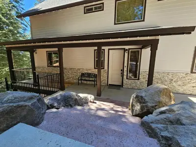 a porch with rocks in front of a house at Cedar Rock Cabin in Mi-Wuk Village