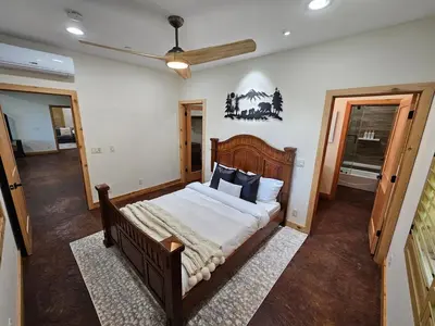 a bedroom with a large bed with a wooden headboard at Cedar Rock Cabin in Mi-Wuk Village
