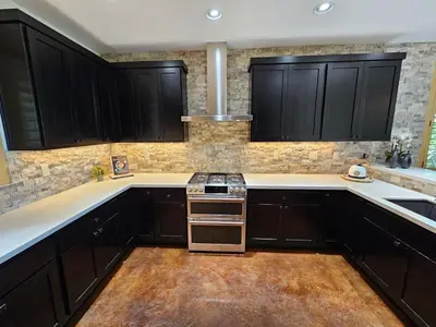a kitchen with black cabinets and a stove top oven at Cedar Rock Cabin in Mi-Wuk Village