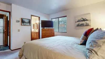 a bedroom with a bed and a flat screen tv at Mammoth Sierra Townhomes #25 condo in Mammoth Lakes