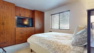 a bedroom with a bed and a flat screen tv at Mammoth Sierra Townhomes #25 condo in Mammoth Lakes