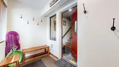 a hallway with a table and a chair and a door at Mammoth Sierra Townhomes #25 condo in Mammoth Lakes