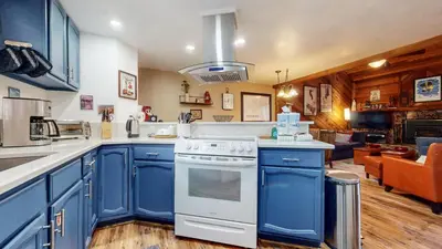 a kitchen with blue cabinets and a stove top oven at Mammoth Sierra Townhomes #25 condo in Mammoth Lakes