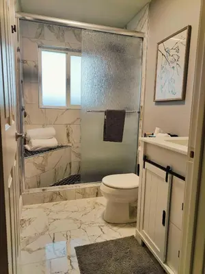 a bathroom with a shower and a toilet and a sink at Old Fig House - Historic Fig Garden Neighborhood in Fresno