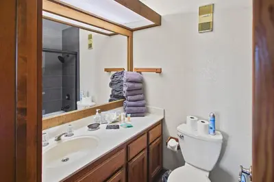 a bathroom with a sink and a toilet and a mirror at Corner 3BD with Loft! Walk to Canyon and The Village! in Mammoth Lakes