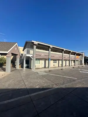 an empty parking lot in front of a building at HomeTown Inn in Los Banos