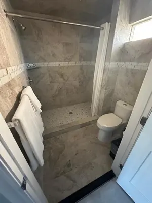 a bathroom with a shower and a toilet at HomeTown Inn in Los Banos