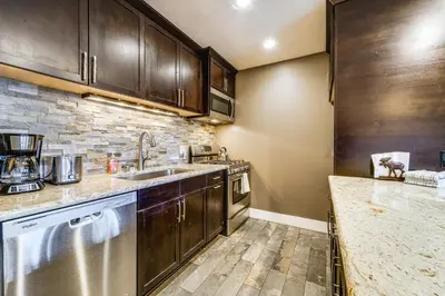 a kitchen with stainless steel appliances and wooden cabinets at Northstar Ski-InandOut Condo with Resort Amenities! in Truckee