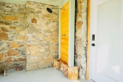 a room with a stone wall and a white door at Lake View Suite for 2-Hot Tub-Dog Friendly in Bass Lake Annex