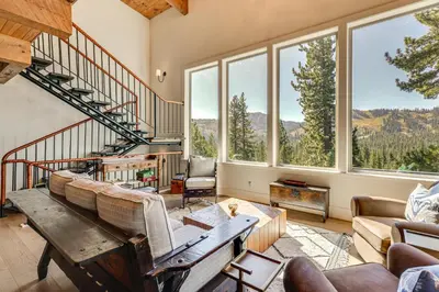a living room with a spiral staircase and windows at Endless Mtn Views! Group Ski Lodge at Sugar Bowl in Norden