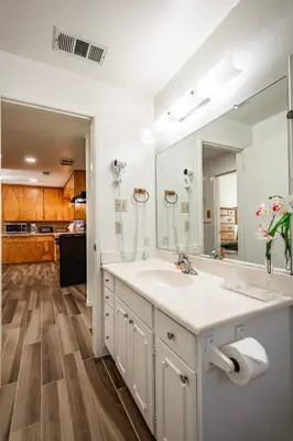 a bathroom with a sink and a large mirror at Cozy Cabin by Bass Lake, with Boat Slip in Bass Lake