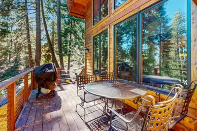a patio with a table and chairs on a deck at Tahoe Timber Retreat in Carnelian Bay