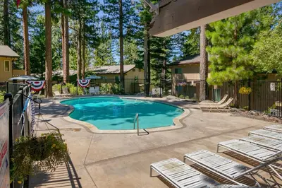 a swimming pool with lounge chairs and trees at Sierra Snow Haven in Incline Village