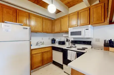 a kitchen with wooden cabinets and a white refrigerator at Val D'Isere 30 in Mammoth Lakes