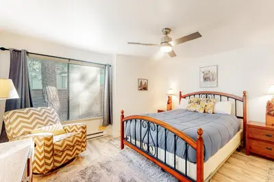 a bedroom with a bed and a chair and a window at Sunshine Village 169 in Mammoth Lakes