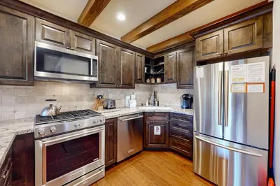 a kitchen with wooden cabinets and stainless steel appliances at Val D'Isere 16 in Mammoth Lakes
