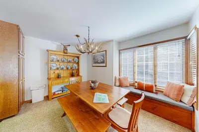 a dining room with a wooden table and a window at Sierra Megeve 3 in Mammoth Lakes