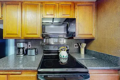 a kitchen with a stove and a microwave at Sierra Megeve 3 in Mammoth Lakes