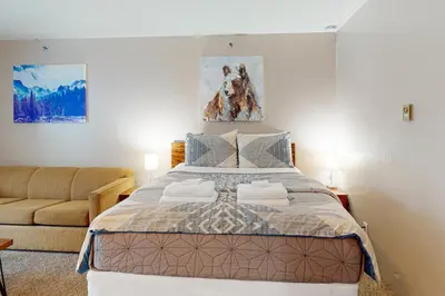 a bedroom with a large bed and a couch at Yosemite West Condo B104 in Yosemite West