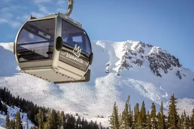 a gondola is flying over a snow covered mountain at Fireside 111 in Mammoth Lakes
