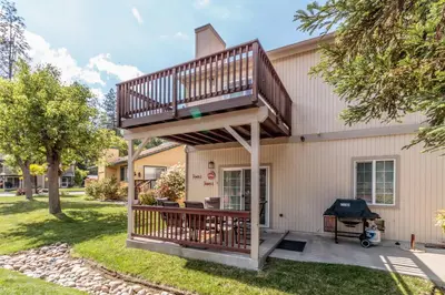 a deck on the side of a house with a grill at Moler Lake House in Bass Lake