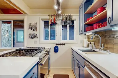 a kitchen with white counters and blue cabinets at Camp Tahoe in Incline Village