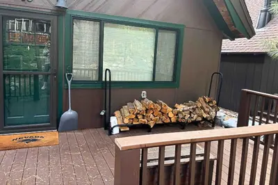 a pile of wood sitting on a porch with a bench at Camp Tahoe in Incline Village