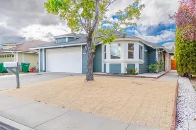 a house with a tree in the driveway at Modern Western Retreat Pet Friendly 4 Bed 2 Bath in Reno