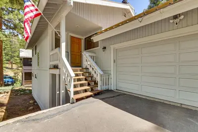 a house with a garage door and an american flag at 3 Mi to Lake Tahoe Forest-View Sanctuary with Deck! in Incline Village