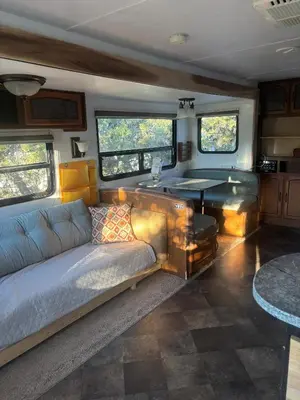 a living room with a couch and a table in an rv at Comfortable Guest RV With EV charger Semi Rural Area in Bodfish
