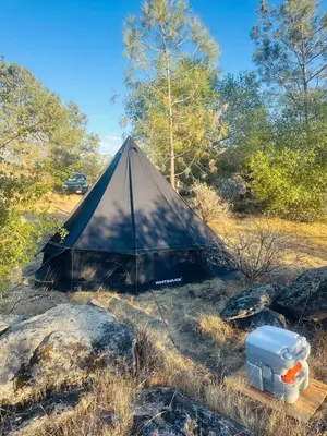 a black tent sitting in the middle of a field at Rocky Ridge Glamping Yosemite in Coarsegold