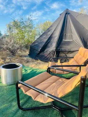 a chair sitting in front of a tent at Rocky Ridge Glamping Yosemite in Coarsegold