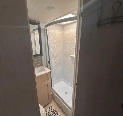 a small bathroom with a shower and a sink at DDs Country Camper in Reedley