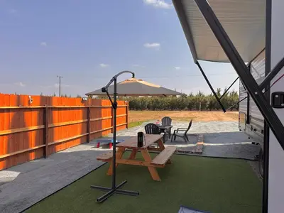 a patio with a picnic table and an umbrella at DDs Country Camper in Reedley