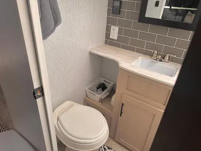 a small bathroom with a toilet and a sink at DDs Country Camper in Reedley