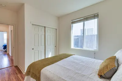 a white bedroom with a bed and a window at 7 Mi to Lake Yosemite Family Home with Fenced Yard in Merced