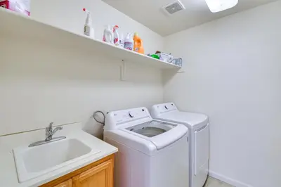 a white laundry room with a sink and a washing machine at 7 Mi to Lake Yosemite Family Home with Fenced Yard in Merced