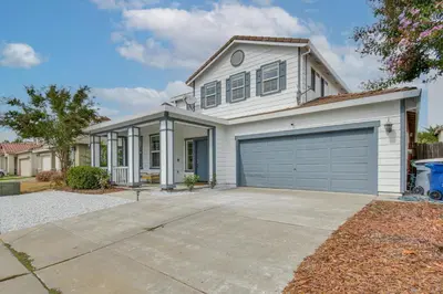 a white house with a garage at 7 Mi to Lake Yosemite Family Home with Fenced Yard in Merced