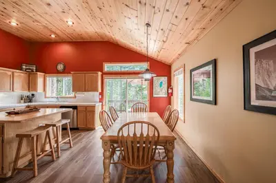 a kitchen with a wooden table and chairs at Scarlet Hollow Cabin at Tahoe Donner by Tahoe Getaways - 3BR w HOA Amenities in Truckee