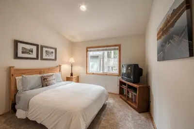 a bedroom with a bed and a television at Scarlet Hollow Cabin at Tahoe Donner by Tahoe Getaways - 3BR w HOA Amenities in Truckee