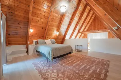 a bedroom with a bed in a room with wooden ceilings at Sequoia Vintage A-frame River Retreat in Three Rivers