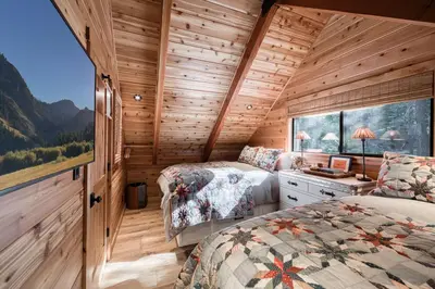 two beds in a room with a window at Songbird Cabin at Chambers by Tahoe Getaways - Pet-Friendly 2 BR with HOA Access in Homewood