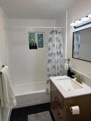 a white bathroom with a tub and a sink at 2 bed 1 bath special woodlake duplex A in Sacramento