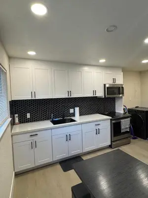 a kitchen with white cabinets and a sink and a stove at 2 bed 1 bath special woodlake duplex A in Sacramento