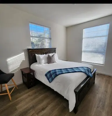 a bedroom with a large bed and two windows at Home away from Home - 6 miles from the SNP in Three Rivers