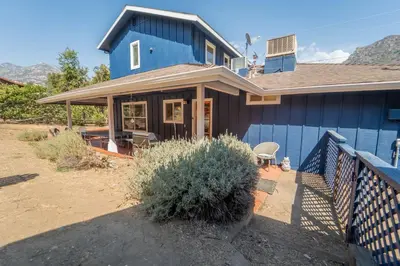 a blue house with a fence in front of it at Gateway To Sequoia River House in Three Rivers