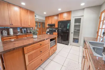 a large kitchen with wooden cabinets and a sink at Gateway To Sequoia River House in Three Rivers